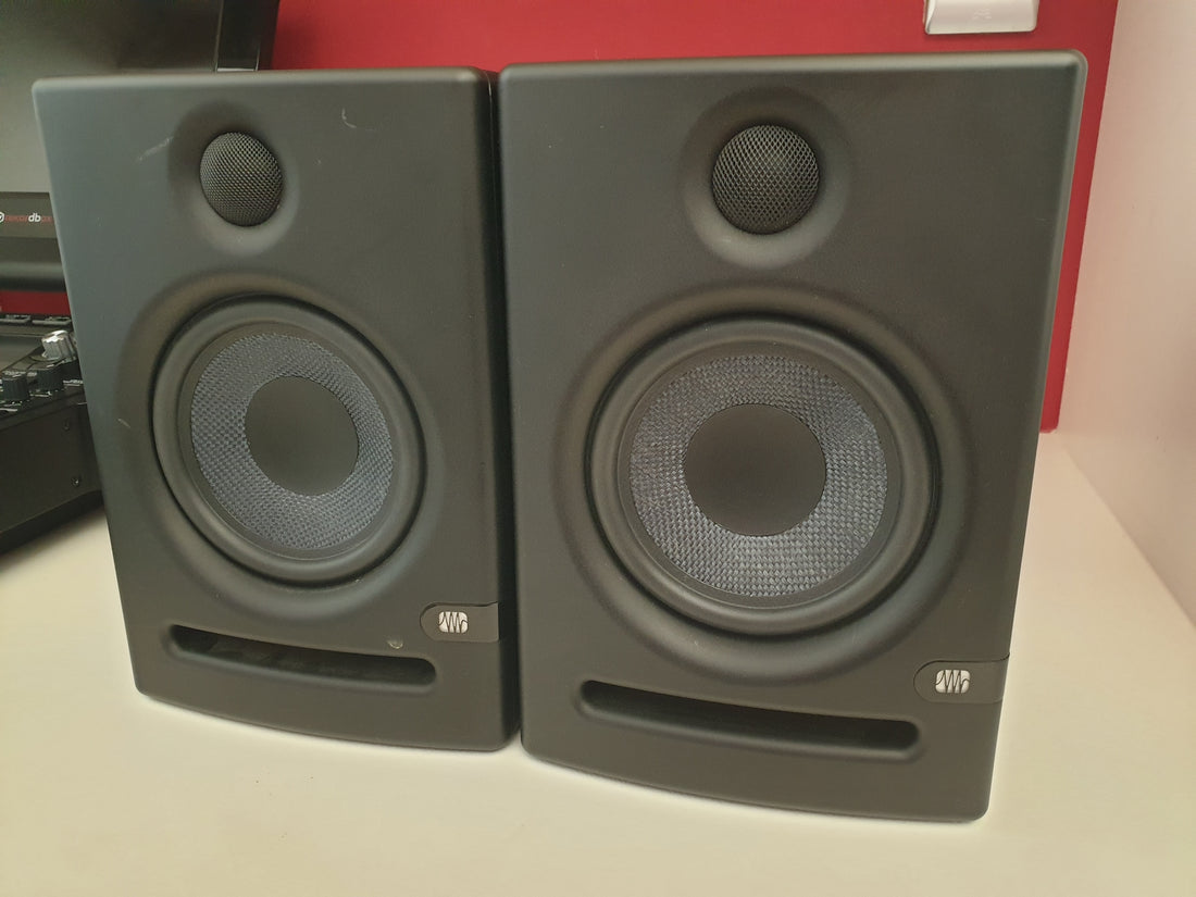 Pair of black studio monitors with blue lights on a white background
