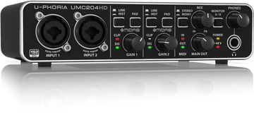Audio interface with multiple knobs and buttons on a reflective surface