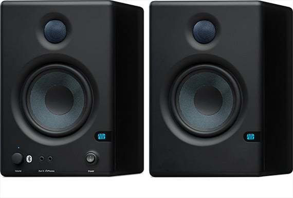 Pair of black studio monitors with visible brand logo on a white background