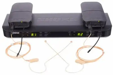 Shure wireless microphone transmitter with earpieces on a white background